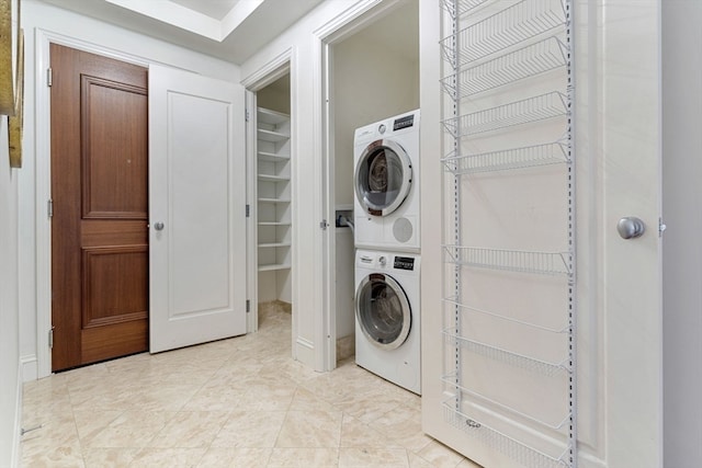 washroom featuring stacked washer and clothes dryer and light tile patterned floors