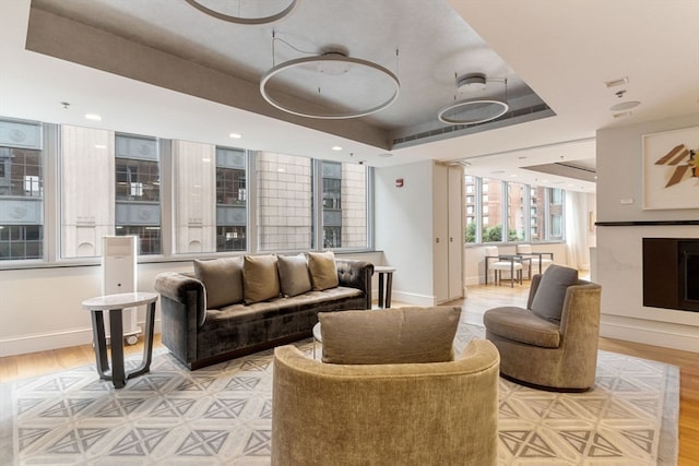 living room featuring light hardwood / wood-style floors and a tray ceiling