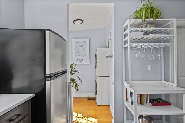 kitchen featuring vaulted ceiling, light hardwood / wood-style flooring, stainless steel refrigerator, and white refrigerator