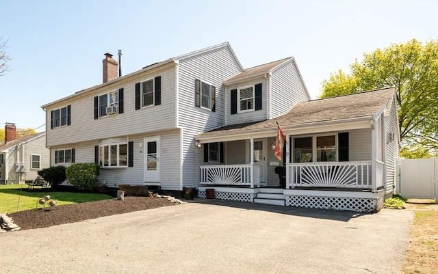 colonial-style house with a porch and a chimney