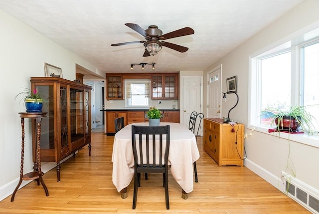 dining room with visible vents, light wood-style flooring, ceiling fan, and baseboards