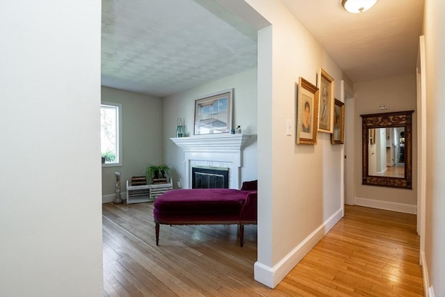 hall with baseboards and light wood finished floors