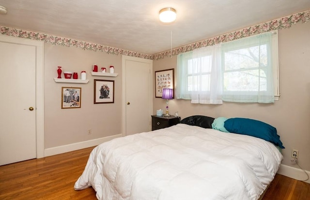 bedroom featuring baseboards and wood finished floors