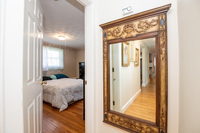 hallway with baseboards and wood-type flooring