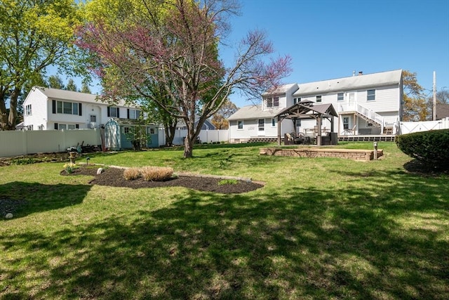 view of yard with a gazebo, a fenced backyard, and an outbuilding