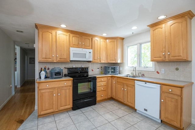 kitchen with a sink, decorative backsplash, white appliances, and light countertops