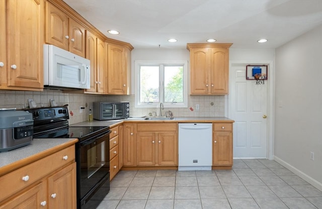 kitchen featuring recessed lighting, a sink, decorative backsplash, and white appliances