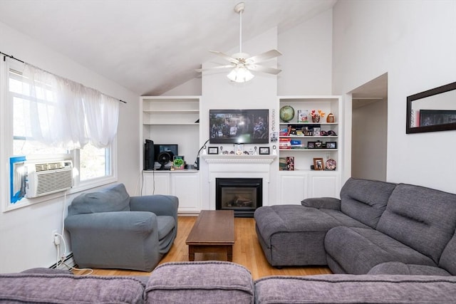 living area with ceiling fan, a fireplace, wood finished floors, vaulted ceiling, and a baseboard heating unit
