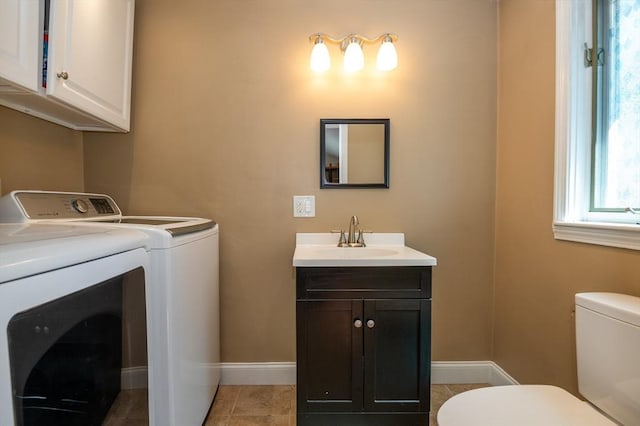 laundry area with laundry area, a sink, baseboards, light tile patterned floors, and washing machine and dryer