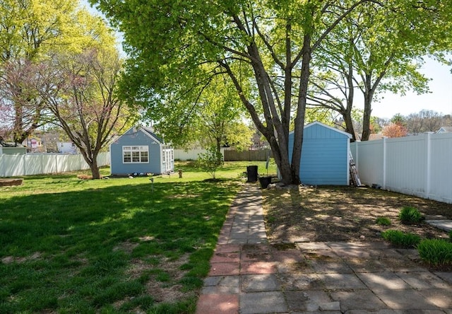 view of yard with an outdoor structure, a fenced backyard, and a storage shed