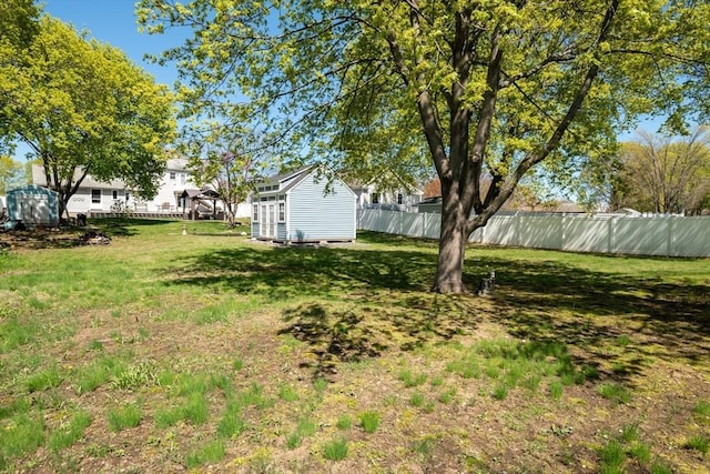 view of yard with fence and an outbuilding