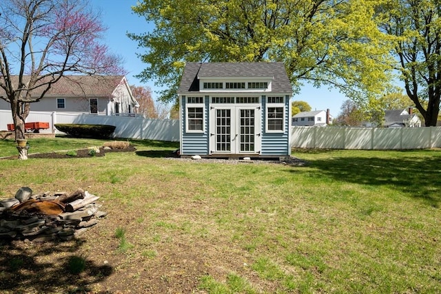 view of outbuilding with a fenced backyard, an outbuilding, and an outdoor fire pit