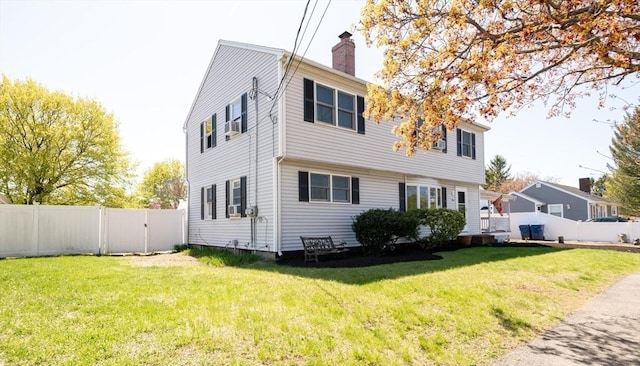 exterior space featuring fence, a chimney, and a yard