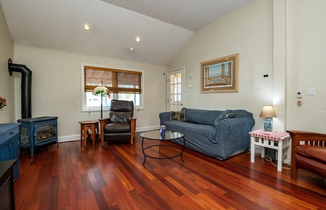 living room featuring vaulted ceiling, baseboards, a wood stove, and hardwood / wood-style flooring