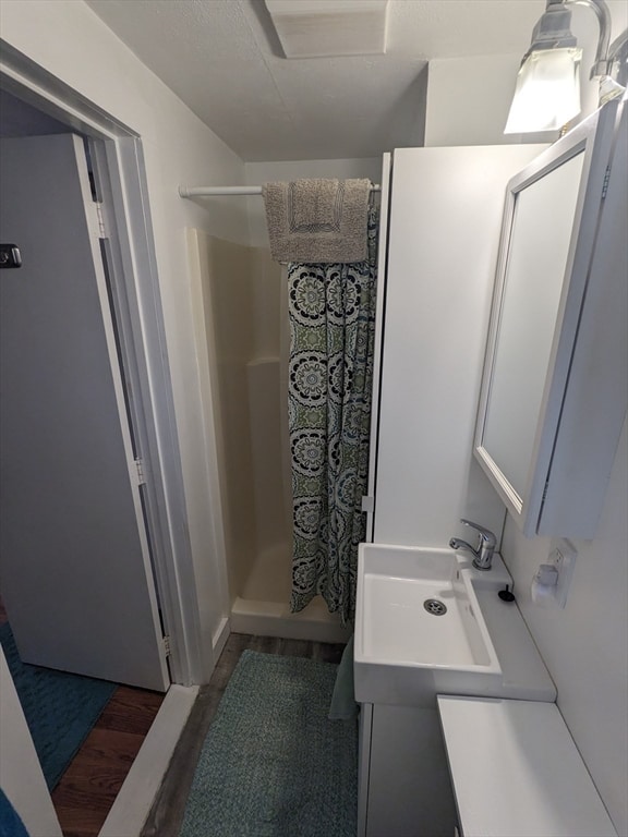 bathroom with wood-type flooring, vanity, and a shower with shower curtain