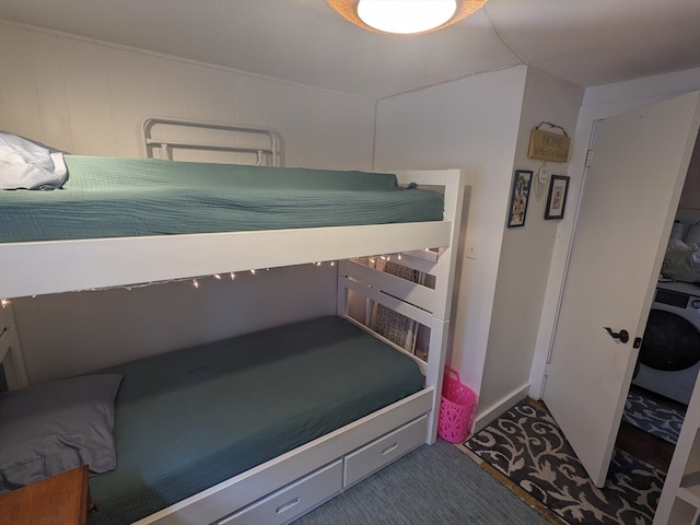 bedroom with washer / dryer and dark carpet