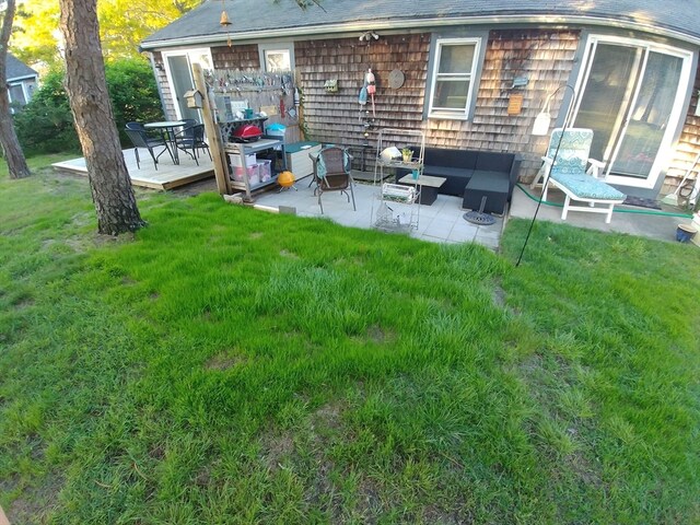 view of yard with a deck, an outdoor living space, and a patio area