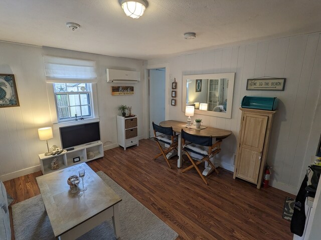 living room featuring an AC wall unit and dark hardwood / wood-style floors