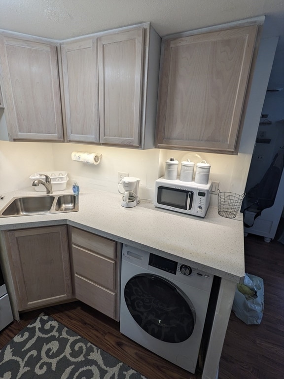 laundry area featuring sink, dark hardwood / wood-style flooring, and washer / clothes dryer