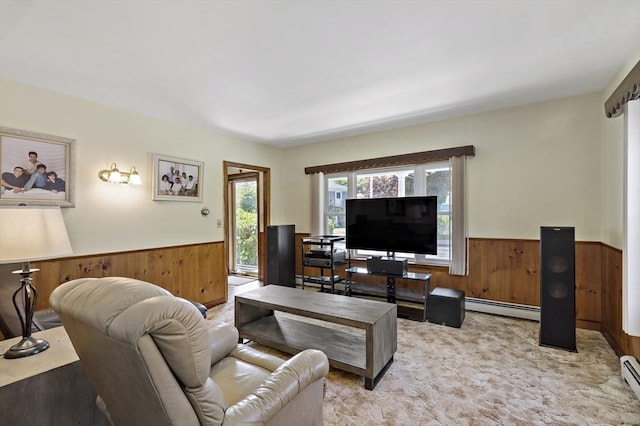 carpeted living room with a baseboard radiator, a wainscoted wall, and wood walls