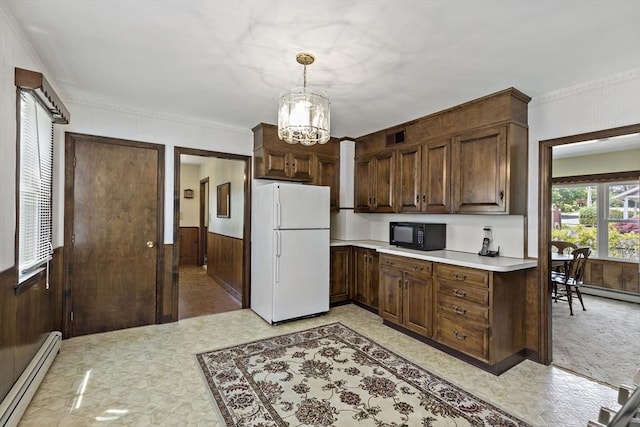kitchen featuring freestanding refrigerator, black microwave, a baseboard heating unit, light countertops, and light flooring