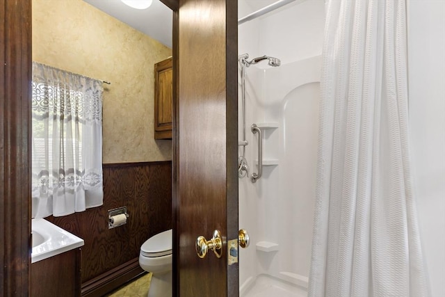 bathroom featuring a shower with shower curtain, toilet, a baseboard radiator, and wainscoting