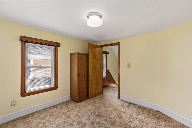 empty room with light carpet and baseboards