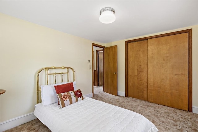 bedroom with carpet, a closet, and baseboards