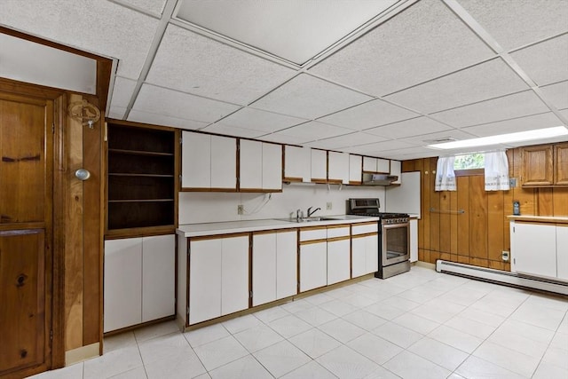 kitchen featuring stainless steel range with gas cooktop, baseboard heating, light countertops, a sink, and a drop ceiling