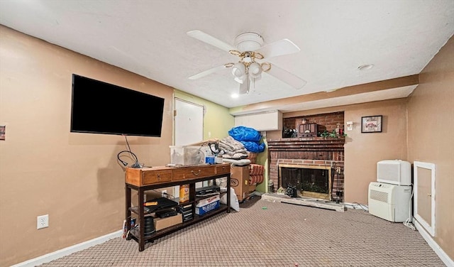 carpeted living area featuring baseboards, a ceiling fan, and a brick fireplace
