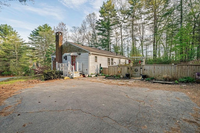 exterior space featuring a gate, fence, and a chimney
