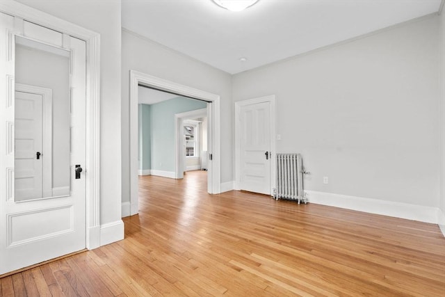 spare room featuring light hardwood / wood-style floors and radiator heating unit