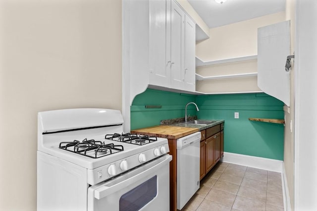 kitchen with white appliances, sink, white cabinetry, butcher block counters, and light tile patterned flooring