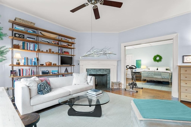 living room with ceiling fan, wood-type flooring, and ornamental molding