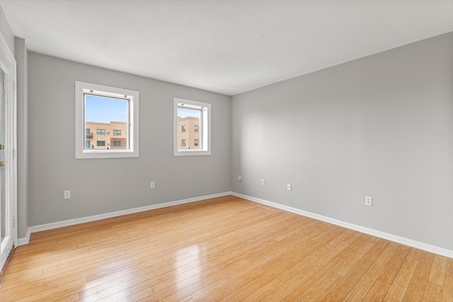 spare room featuring light wood-style flooring and baseboards