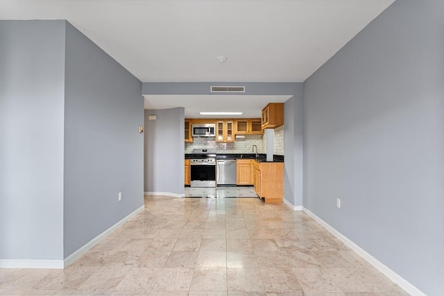 kitchen with visible vents, backsplash, baseboards, dark countertops, and appliances with stainless steel finishes