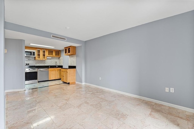 kitchen featuring baseboards, dark countertops, and appliances with stainless steel finishes