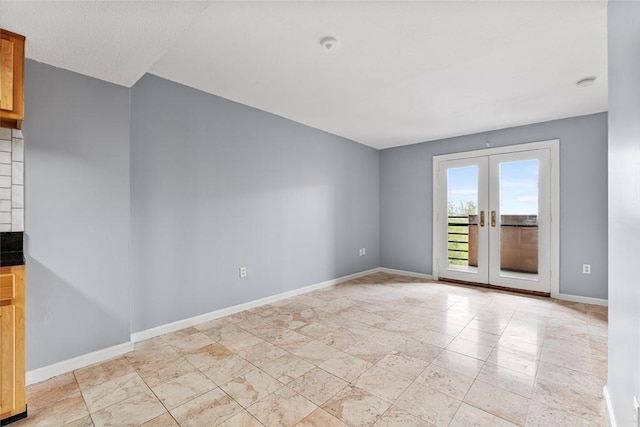 unfurnished room with french doors and baseboards