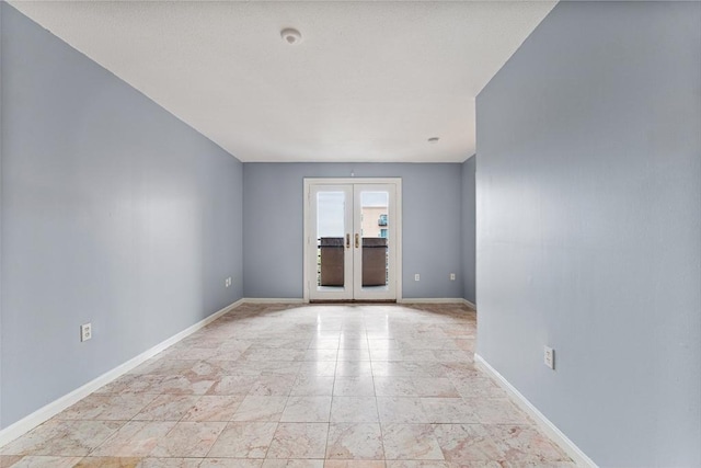 spare room featuring french doors and baseboards