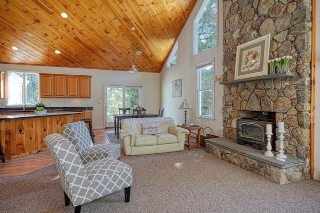 carpeted living room featuring wood ceiling and high vaulted ceiling