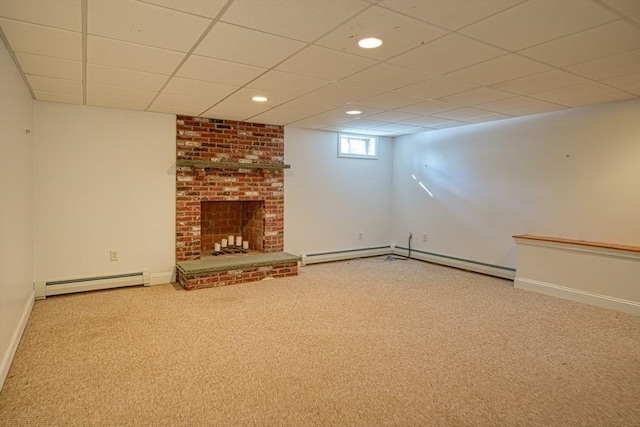 basement featuring a brick fireplace, a paneled ceiling, carpet, and baseboard heating