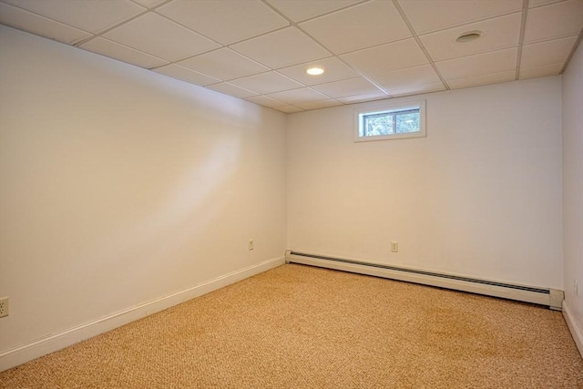 unfurnished room featuring light carpet, a paneled ceiling, and baseboard heating