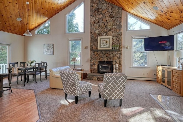 carpeted living room featuring a healthy amount of sunlight, wooden ceiling, and a baseboard heating unit