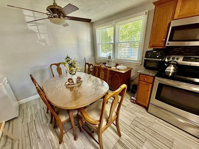 dining area with light wood-style flooring, ceiling fan, and baseboards