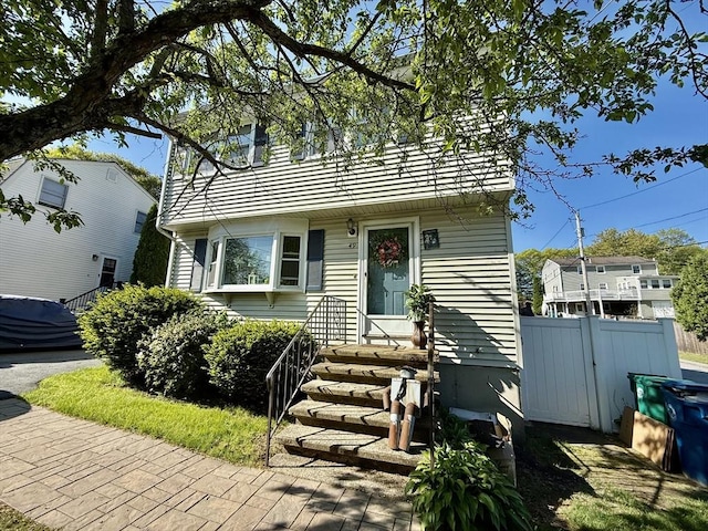 colonial home with entry steps and fence