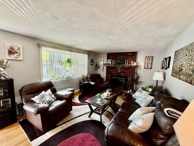 living room with wood finished floors, a textured ceiling, and a fireplace