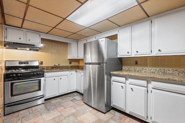 97 Marshall St, Revere, MA 02151 - kitchen featuring appliances with stainless steel finishes, under cabinet range hood, decorative backsplash, light stone finish flooring, and white cabinetry