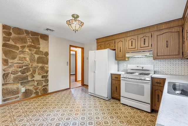 97 Marshall St, Revere, MA 02151 - kitchen with white appliances, under cabinet range hood, light countertops, brown cabinetry, and a textured ceiling