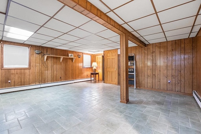 97 Marshall St, Revere, MA 02151 - finished below grade area featuring a baseboard radiator, a paneled ceiling, wood walls, and stone finish floors