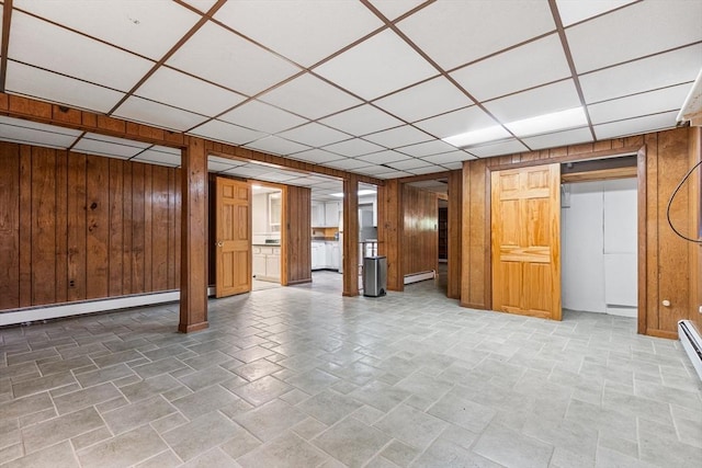 97 Marshall St, Revere, MA 02151 - finished below grade area featuring wooden walls, a paneled ceiling, baseboard heating, and a baseboard heating unit